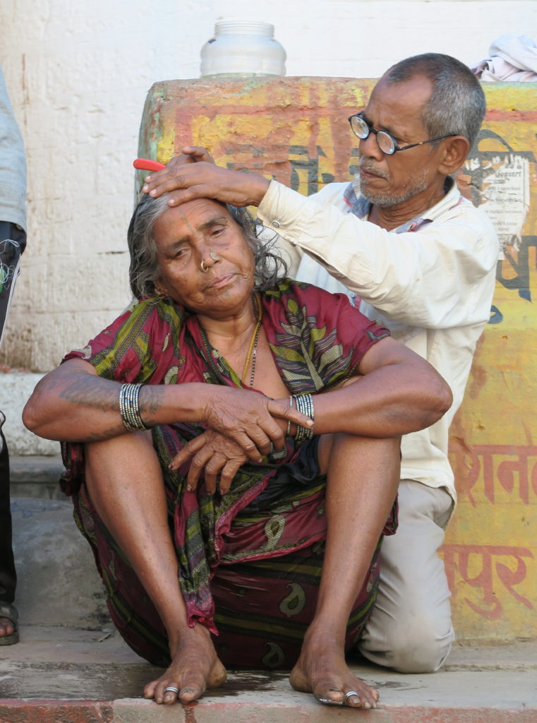 Une vieille femme se coupe les cheveux pour les offrir au Gange