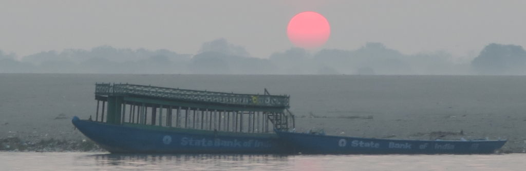 Soleil levant au dessus d'un bateau sur le Gange