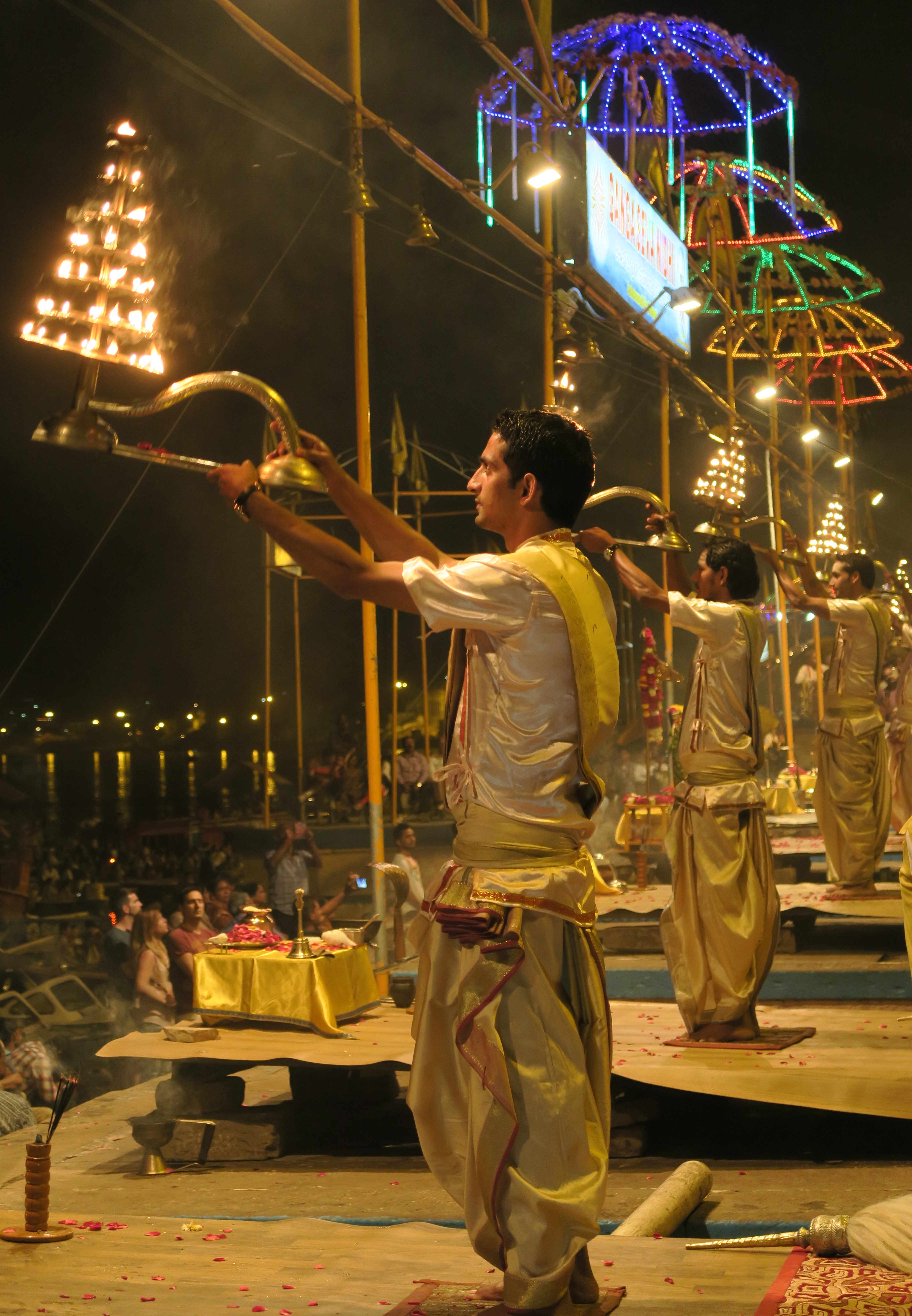 Plusieurs hommes tiennent un chandelier pendant la puja