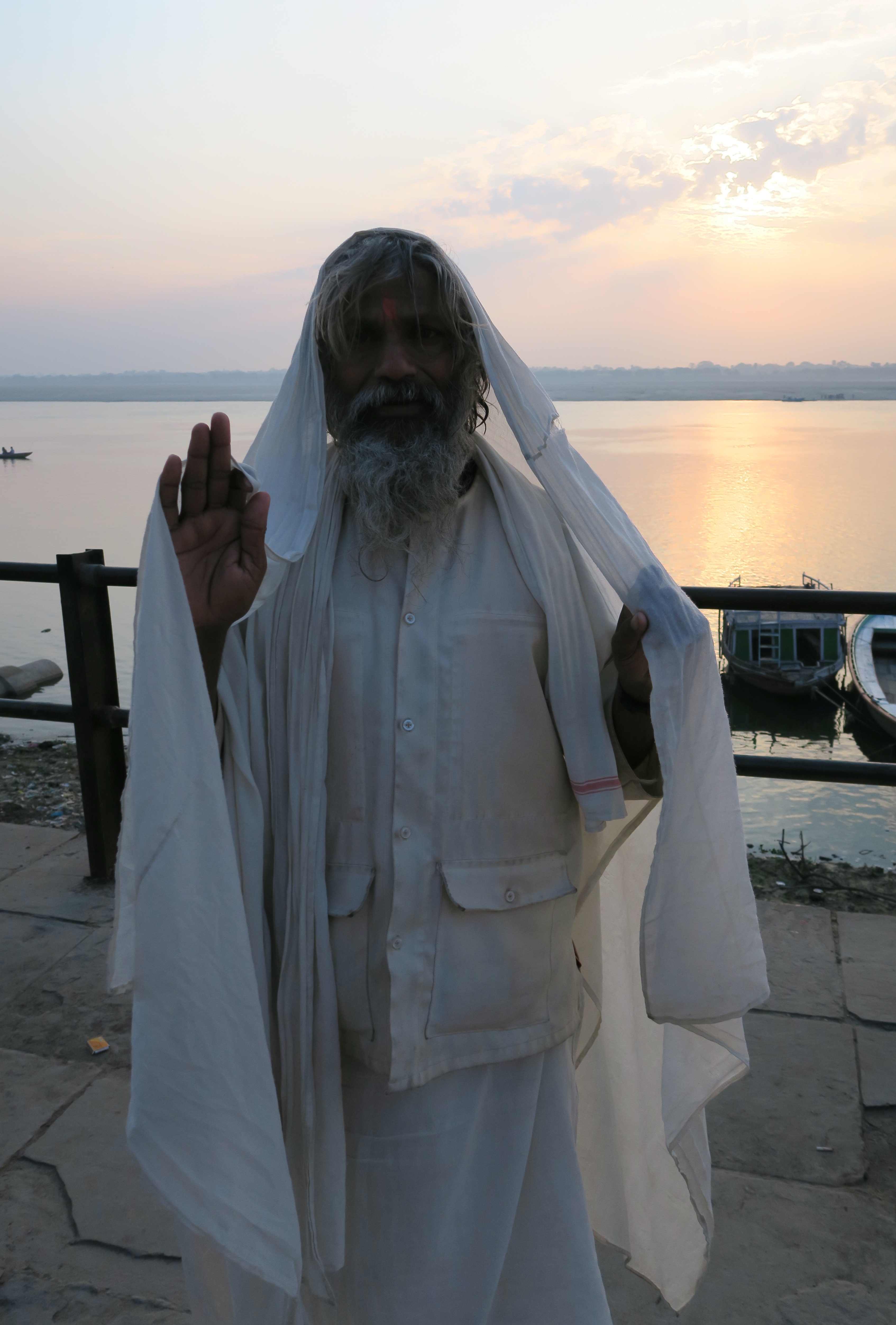 Vieux sadhu habillé en blanc devant le lever du Soleil