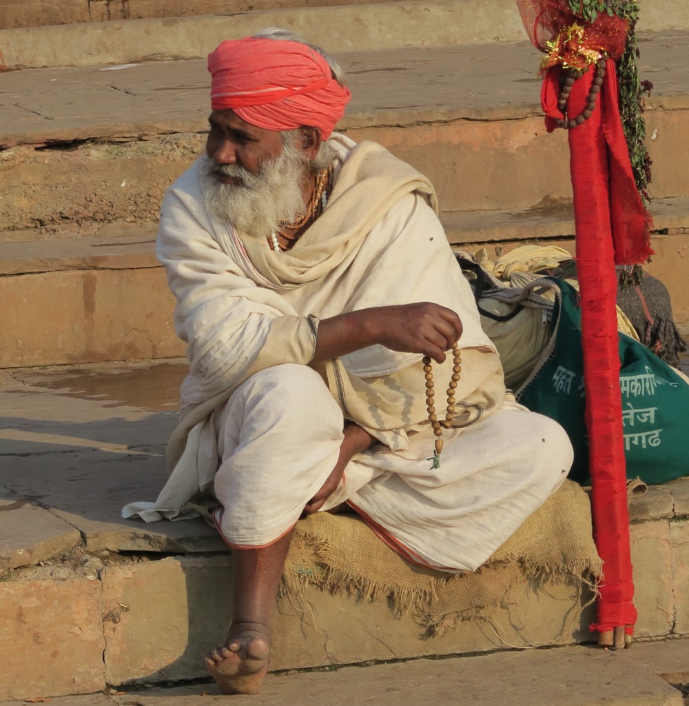 Homme habillé en blanc avec turban rouge et canne