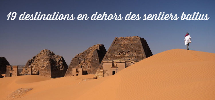 Homme marchant sur des dunes de sable aux pyramides de Méroé au Soudan (destinations en dehors des sentiers battus)