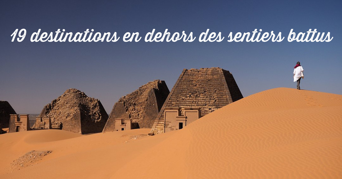 Homme marchant sur des dunes de sable aux pyramides de Méroé au Soudan (destinations en dehors des sentiers battus)