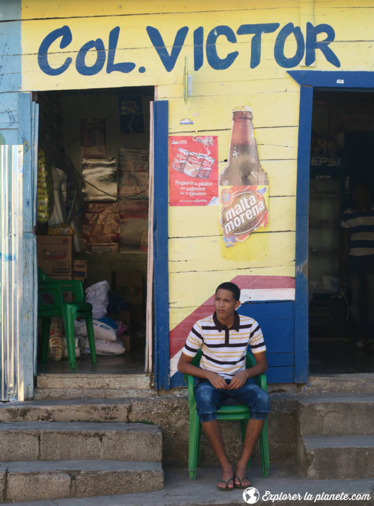 Un homme assis en face d'un commerce en République dominicaine