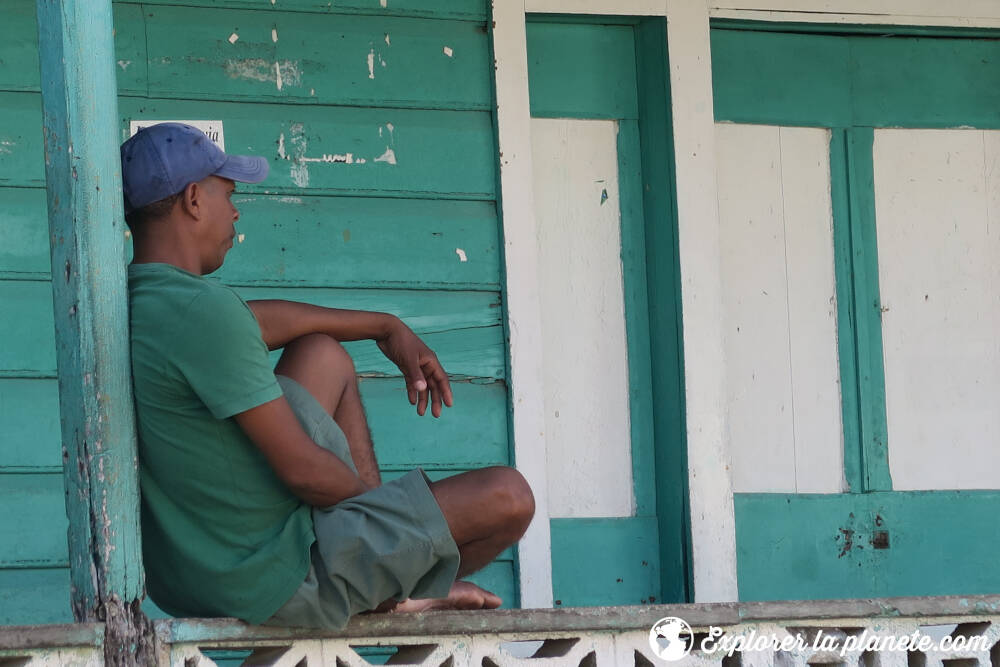 Un homme assis sur le balcon de sa maison en République dominicaine.