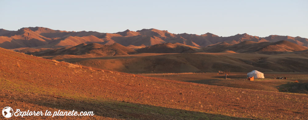 Une yourte dans la steppe au coucher de soleil.