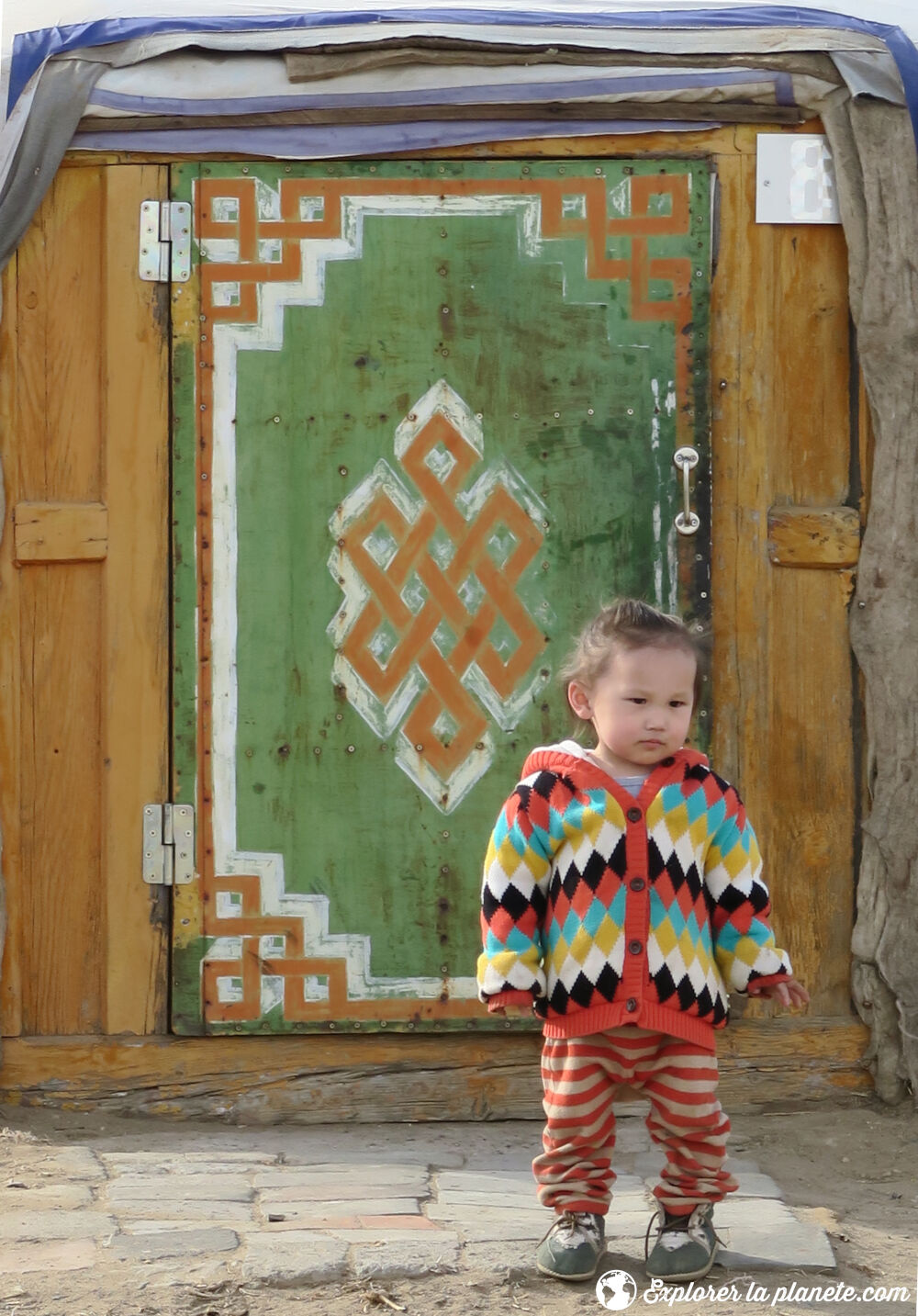 Une jeune fille devant la porte d'une yourte en Mongolie.
