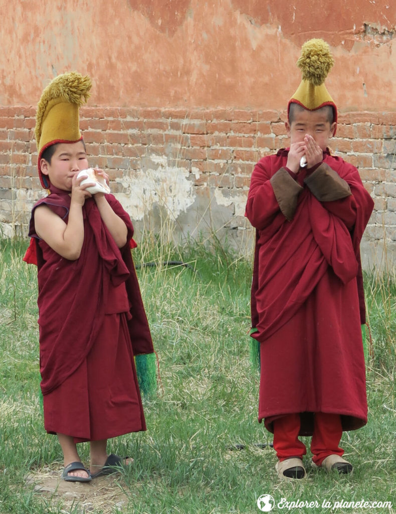 Les jeunes moines qui appellent la prière avec un coquillage au monastère de Amarbayasgalant khiid. 