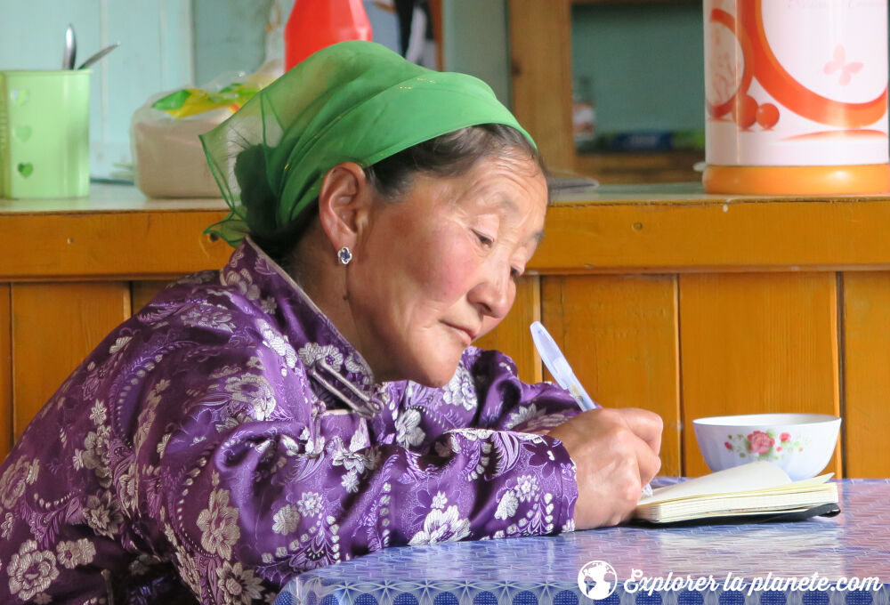 Une vieille dame Mongole qui écrit dans son journal.