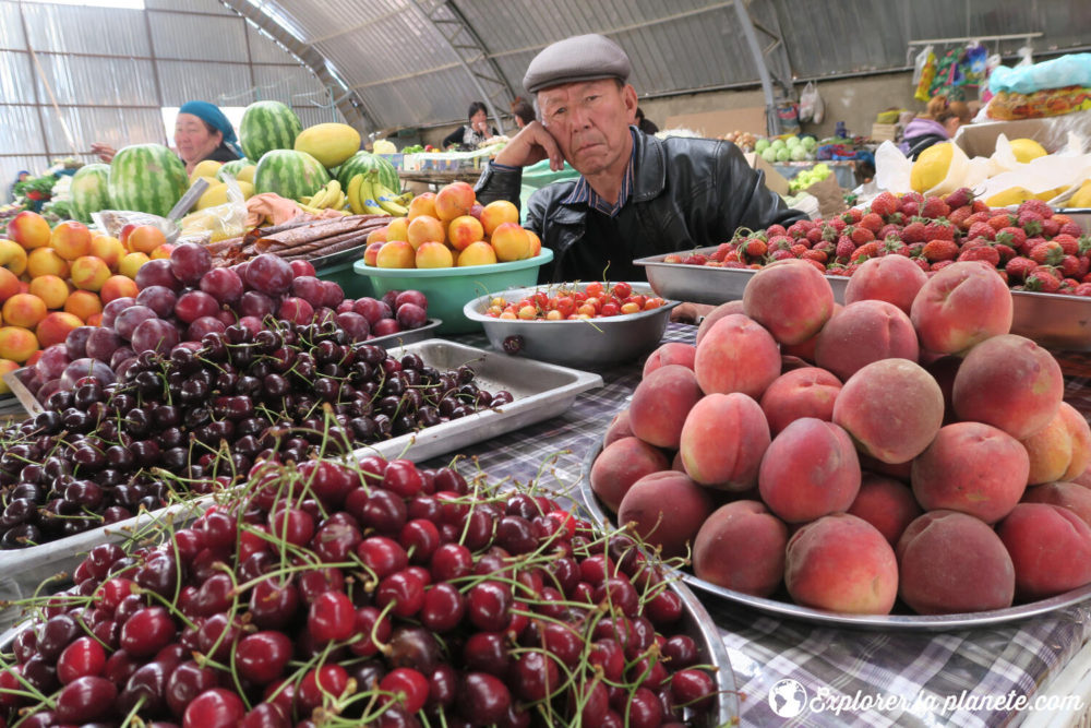 Un homme qui vend des fruits dans un marché au Kirghizistan.