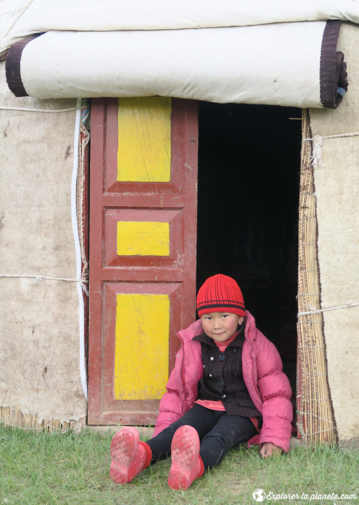 Une jeune fille devant une yourte au Kirghizistan.
