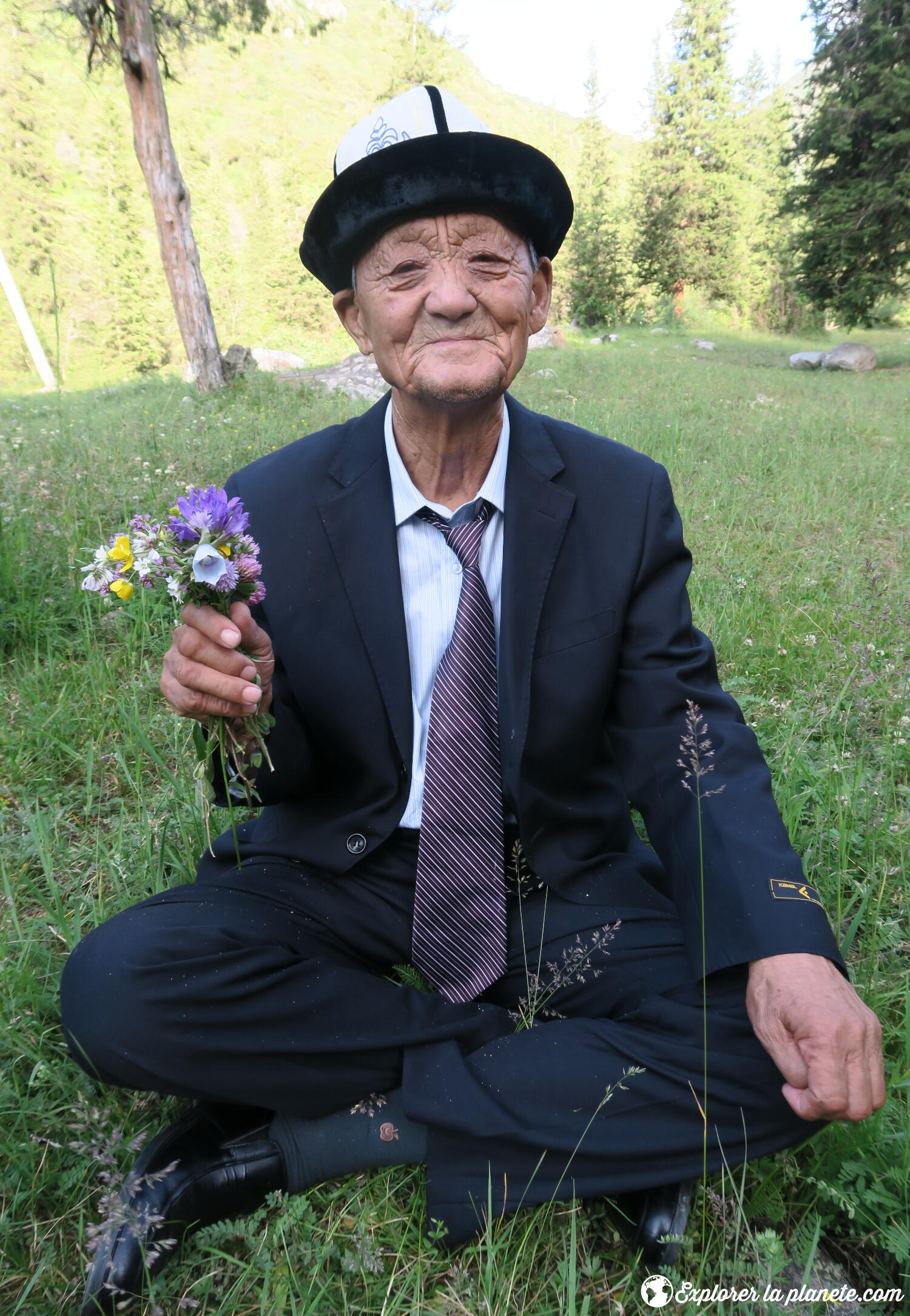 Un vieil homme avec un bouquet de fleur au Kirghizistan.
