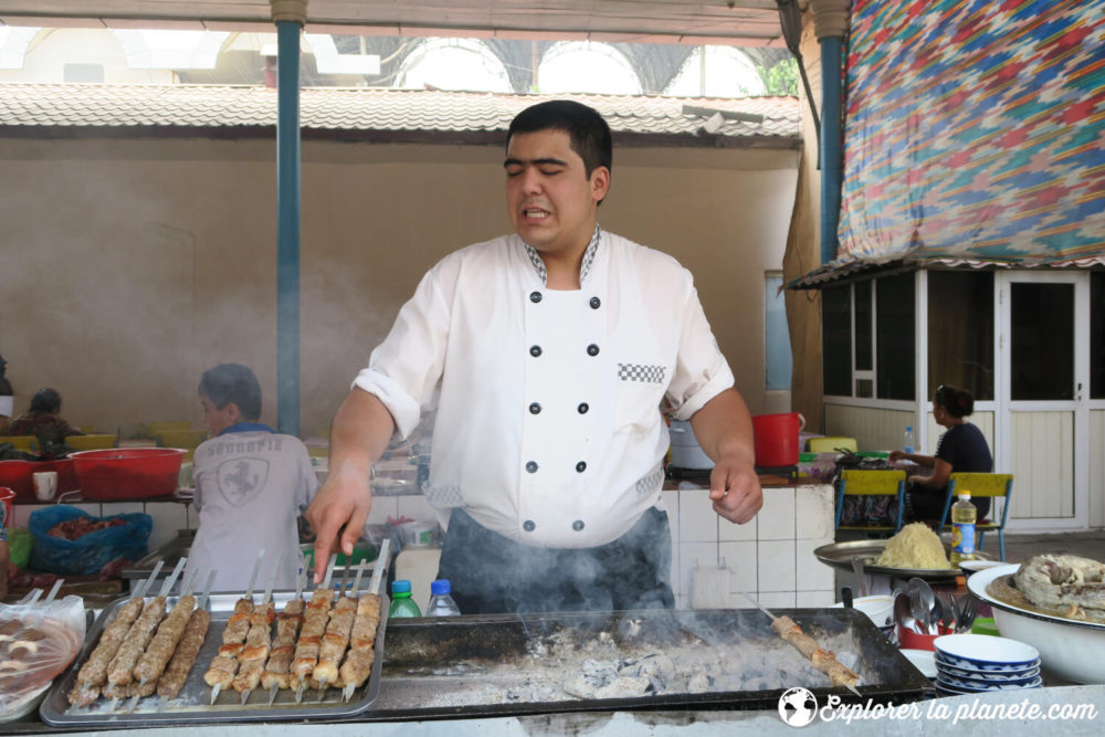 Un cuisinier qui fait un barbecue de chachlicks dans un marché.