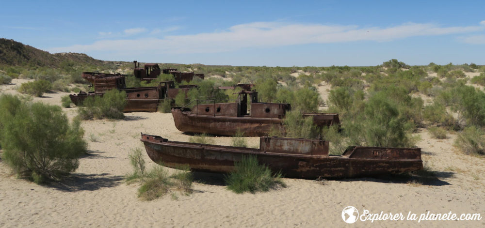 Quelques bateaux rouillés sur le sable en plein milieu du désert où se trouvait la mer d'Aral avant. Désastre écologique.