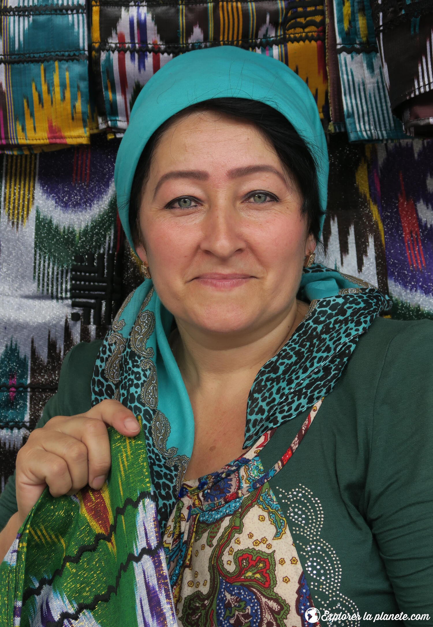 Une dame en Ouzbékistan qui vend des voiles de soie.